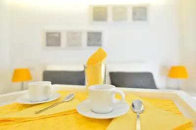 a table with two coffee cups and spoons on it at New Romantic Trastevere Apartment in Rome