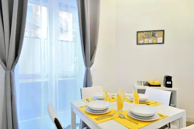 a white dining room table with chairs and a window at New Romantic Trastevere Apartment in Rome