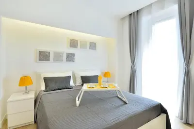 a white bedroom with a bed with a table on it at New Romantic Trastevere Apartment in Rome