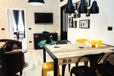 a living room with a wooden table and chairs at BMGA l Stylish Industrial Termini Apartment in Rome