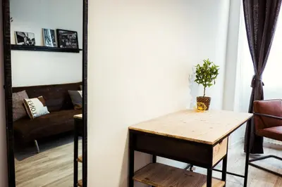 a living room with a table and a couch at BMGA l Stylish Industrial Termini Apartment in Rome