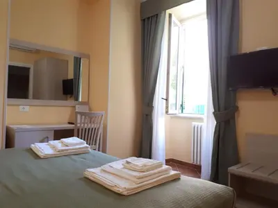 a bedroom with two towels on a bed with a window at Clodio Rooms in Rome