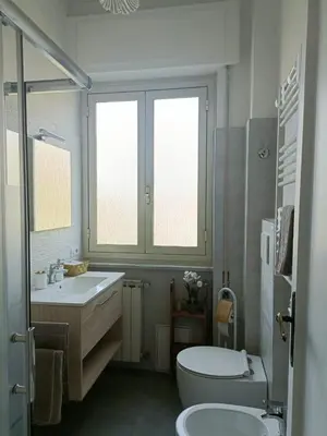 a white bathroom with a sink and a toilet at Tommy Guest House Roma in Rome