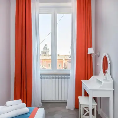a bedroom with orange curtains and a sink and a window at Lata Luxury Penthouse in Rome