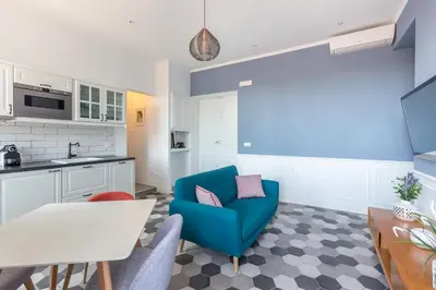 a living room with a blue chair and a kitchen at Lata Luxury Penthouse in Rome