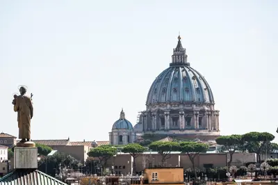 a statue of a man standing in front of a cathedral at Expeditus VATICAN Luxury Suites SAINT PETER'S VIEW in Rome