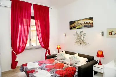 a bedroom with a bed with red curtains and a table at Gateway Residence in Rome