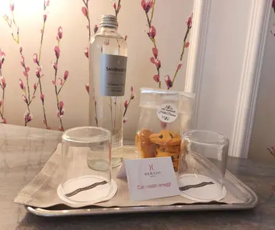 a tray with glasses and a bottle of water and pastries at Hotel Damaso in Rome