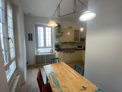 a dining room table with chairs and a kitchen at CASA CENEDA 46 in Rome