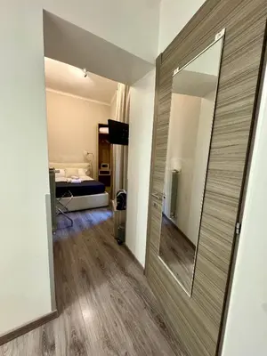 a bathroom with a mirror and a bed in a room at RHS Rienzo Suites in Rome
