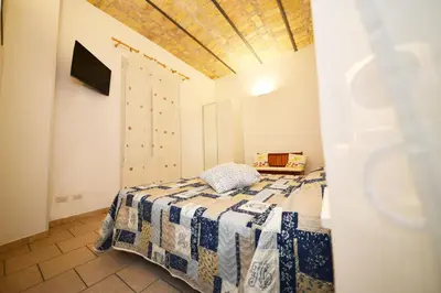 a bedroom with a bed with a blue and white blanket at stars luxury apartments in Rome