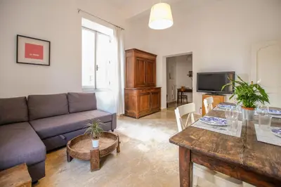 a living room with a couch and a table at Spacious Apartment with Big Terrace at Colosseum in Rome