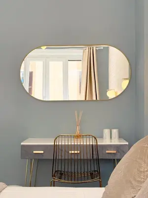 a mirror above a vanity with a chair in a bedroom at San Pietro Rooms 84 in Rome