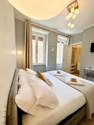 a bedroom with two beds with white pillows at San Pietro Rooms 84 in Rome