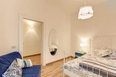a bedroom with a bed and a blue couch at Navona Flat di Elena & Paola in Rome