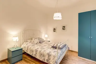 a bedroom with a bed and a blue dresser and a lamp at Navona Flat di Elena & Paola in Rome