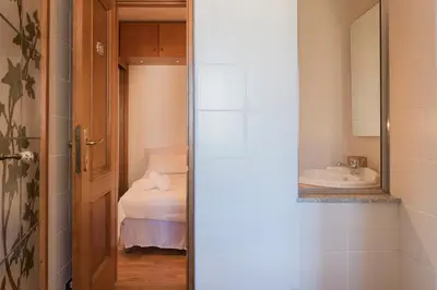 a bathroom with a sink and a toilet and a mirror at Lago Terrione Apartment - Charme Holidays in Rome