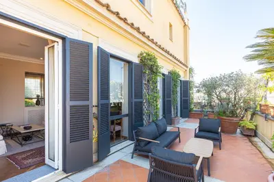 a patio with blue shutters on a building at Rental in Rome - Fontana Di Trevi Penthouse in Rome