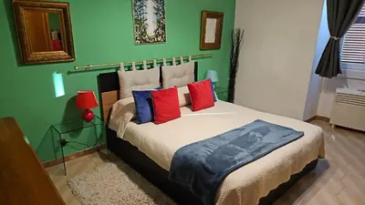 a bedroom with a bed with red and blue pillows at Casa Rossi Roma in Rome