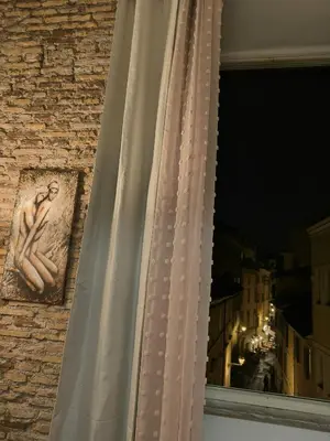 a window with a statue of a man on the side of a building at Marii Piazza Navona in Rome