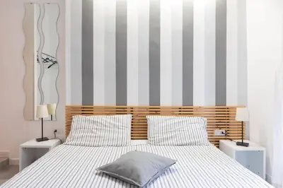 a bedroom with a bed with a striped wall at St Peter Rooms in Rome