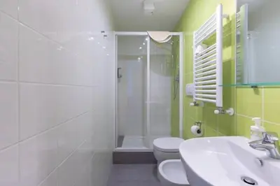 a bathroom with a shower and a toilet and a sink at St Peter Rooms in Rome