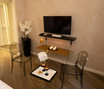a living room with a tv and a table and chairs at Spagna Boutique in Rome