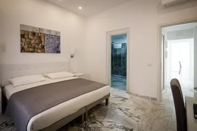a white bedroom with a bed and a bathroom at Vinci House in Rome