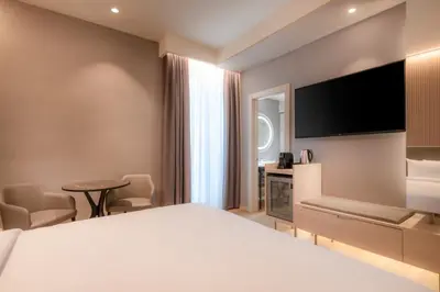 a hotel room with a bed and a flat screen tv at AC Hotel by Marriott Clodio Roma in Rome