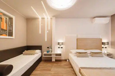 a bedroom with two beds and a table with a lamp at Etruska luxury Trastevere Guesthouse in Rome
