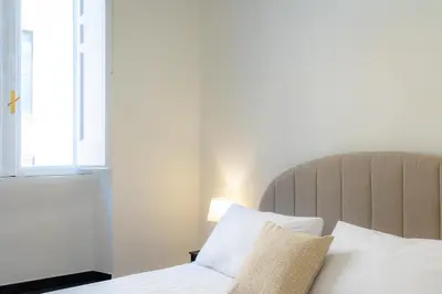 a bedroom with a bed with white sheets and a window at Rental in Rome - Bramante Luxury in Rome