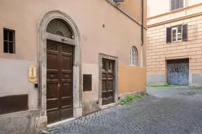 a building with two wooden doors on a street at White flat Rione Monti in Rome