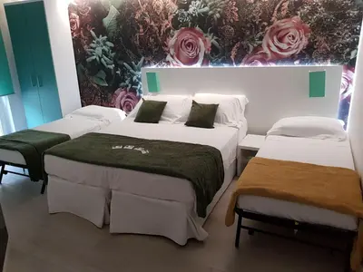 two beds in a room with roses on the wall at Duca's House in Rome