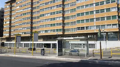 a bus stop in front of a large building at Duca's House in Rome
