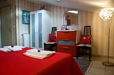 a bedroom with a red bed and two chairs at Alma de Roma in Rome