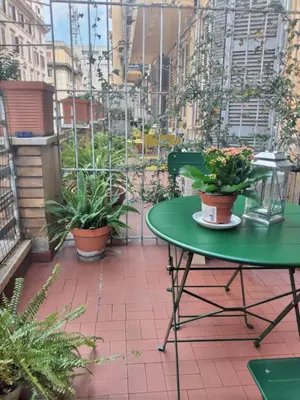 a green table and chairs on a balcony with plants at Hotel Principe Eugenio in Rome