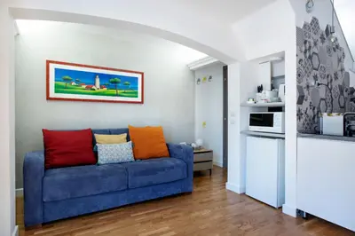 a living room with a blue couch with colorful pillows at Argentina apartment Roof View in Rome