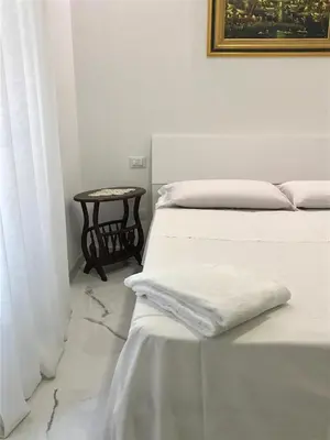 two beds in a white room with a table at B&B Palombini in Rome