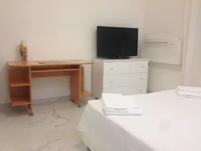 a bedroom with a desk and a television on top of a bed at B&B Palombini in Rome
