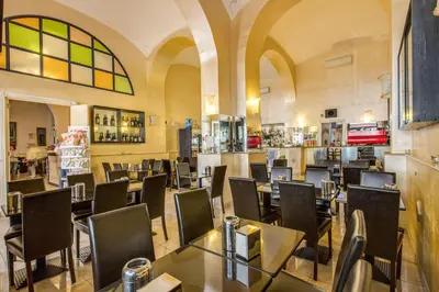 a restaurant with tables and chairs in a room at Hotel Maryelen in Rome