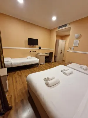 a hotel room with two beds and a desk at PapavistaRelais in Rome