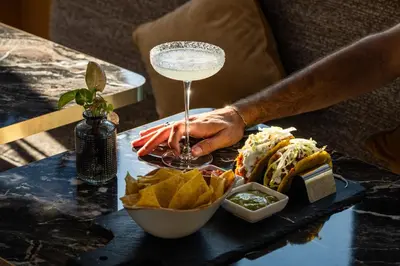 a person holding a drink on a table with food at 9Hotel Cesari in Rome
