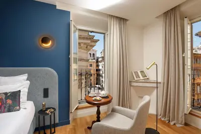 a hotel room with a bed and a chair and a window at 9Hotel Cesari in Rome