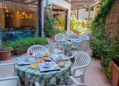 a table and chairs with food on a patio at Hotel La Pergola in Rome