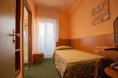 a hotel room with two beds and a window at Hotel La Pergola in Rome