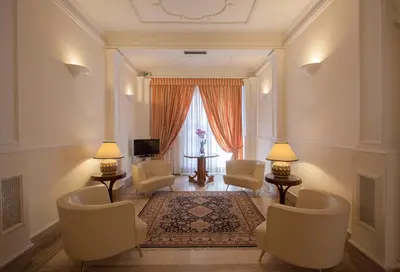 a living room with chairs and a table and a window at Hotel Laurentia in Rome