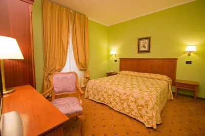 a hotel room with a bed and a chair at Hotel Laurentia in Rome