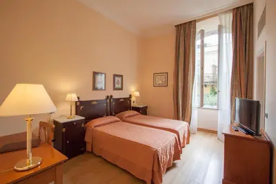 a hotel room with a bed and a television at Ateneo Garden Palace in Rome