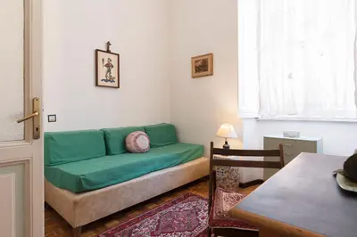 a living room with a green couch and a table at Flower's Market Apartment - Charme Holidays in Rome