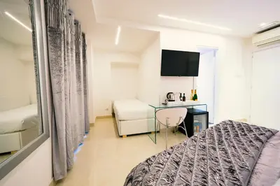 a bedroom with a bed and a desk and a tv at San Pietro Grand Suite in Rome